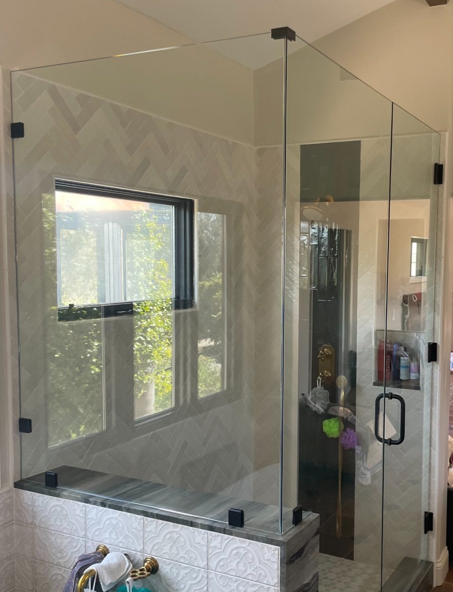 SBG: Frameless Shower Enclosure Modern glass shower enclosure in a bright bathroom with large window.